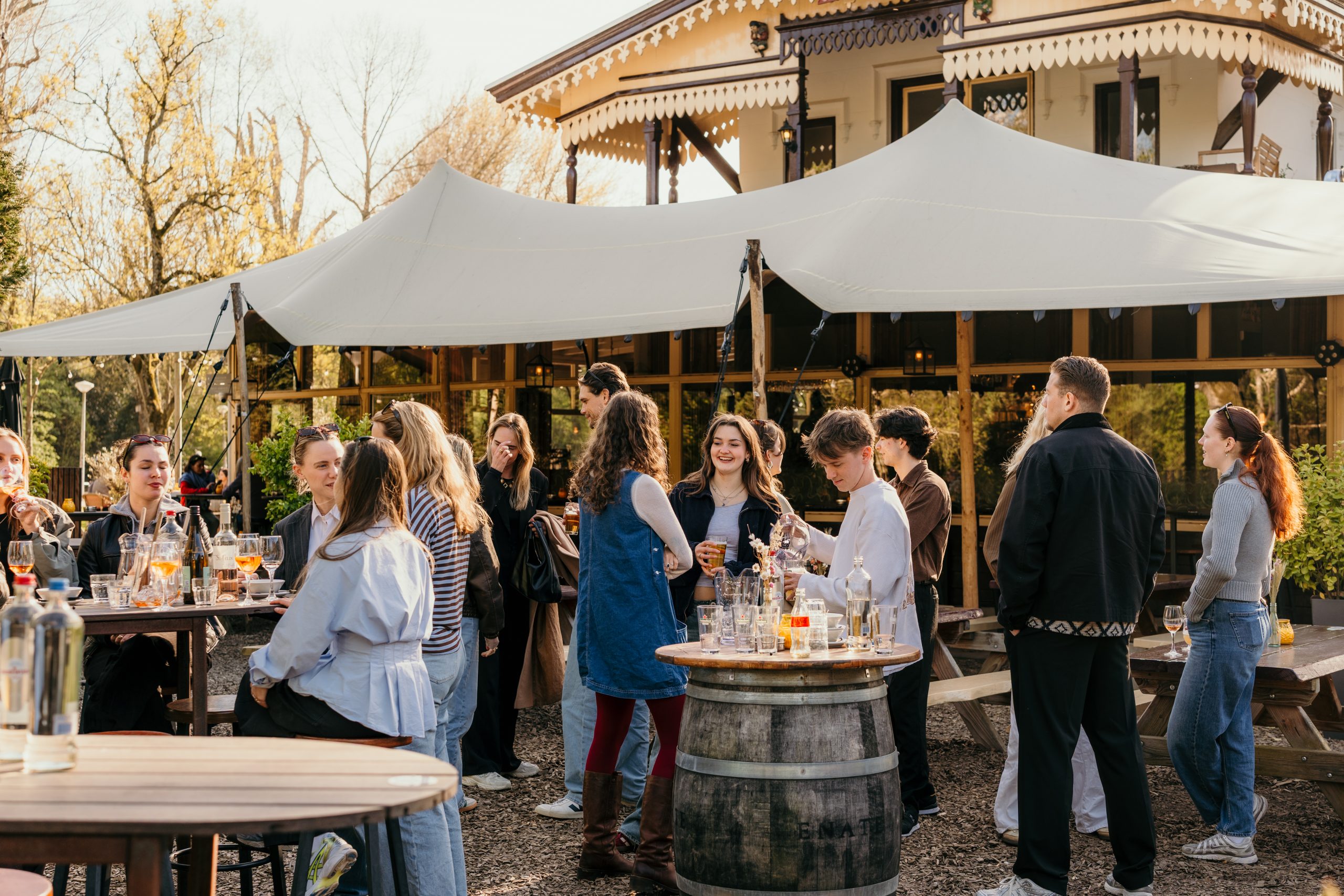 Groep gasten geniet van een borrel of diner op het terras van Groot Melkhuis in het Vondelpark.